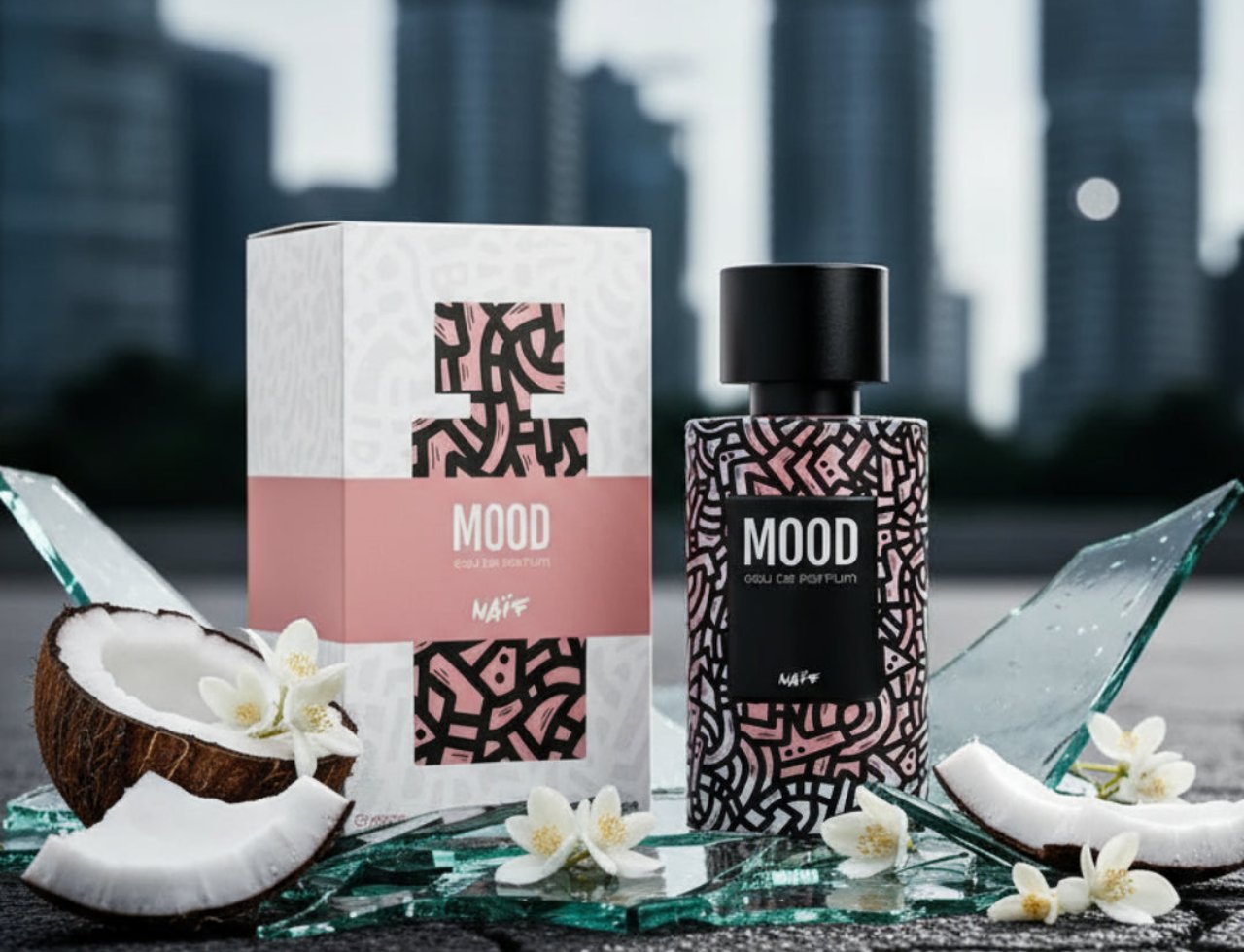 Mood Perfume Mood Naif For Her – 100 ml untuk Wanita, menampilkan botol minyak wangi dan kotaknya, dikelilingi kaca pecah, potongan kelapa, dan bunga putih berlatarkan latar bandar yang kabur.