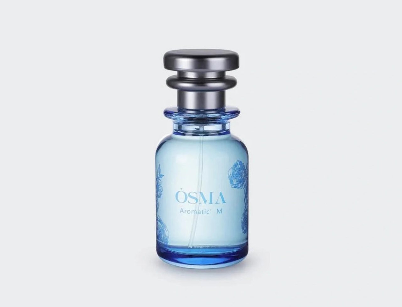 Osma Aromatic M Essence of Nature 75ml — Botol minyak wangi kaca biru jernih dengan penutup perak, menampilkan corak bunga ros biru pada kaca.
