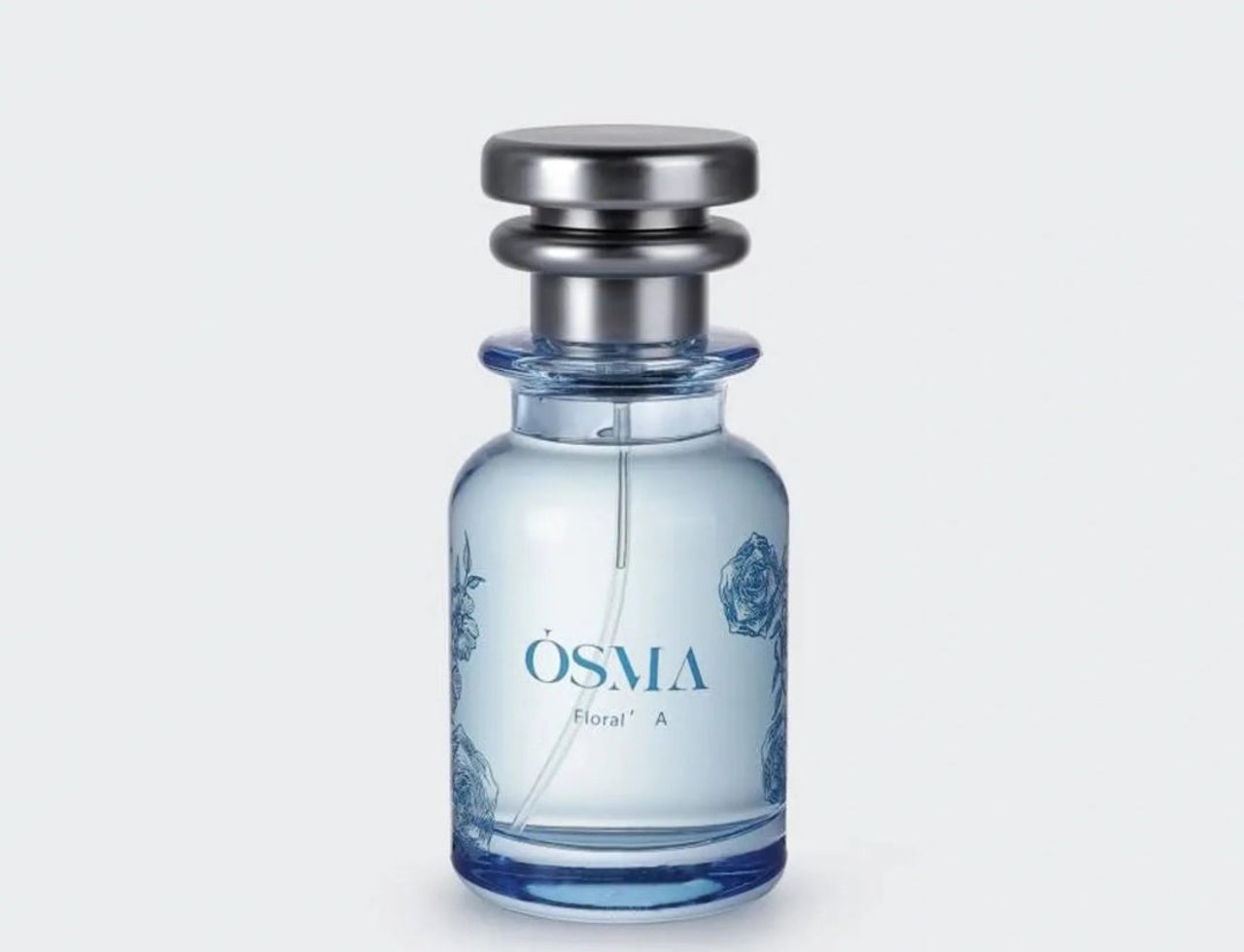 Osma Osma Floral A Ginger Blossom 75ml — A clear glass perfume bottle with blue floral accents and a silver cap, set against a plain white background.