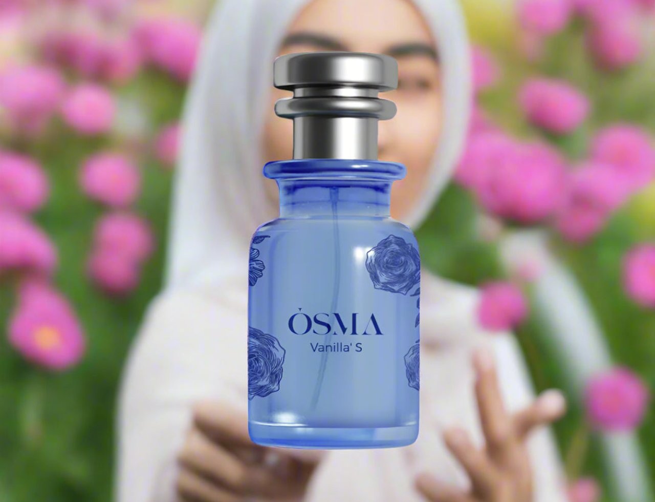 Osma Vanilla S Amber & Musk 75ml EDP — Blue glass perfume bottle with rose pattern, silver cap, set against a blurred background of pink flowers and a woman in a white hijab.