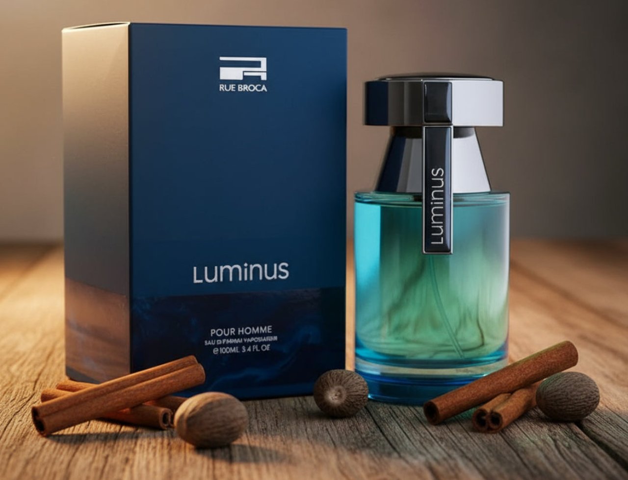 Rue Broca Luminus Pour Homme by Rue Broca 100ml Men — Blue box and glass bottle with blue liquid, with cinnamon sticks and nutmeg on wooden surface