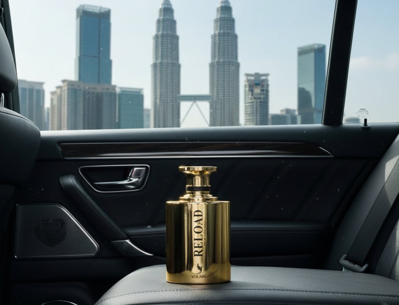 Volare Reload Gold by Volare Man – 100 ml for Him, a golden perfume bottle with 'RELOAD' text, placed on a car seat with a cityscape view of Kuala Lumpur's Petronas Twin Towers in the background.