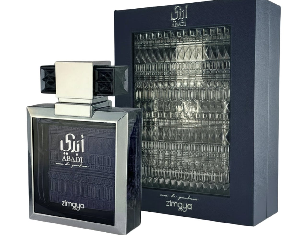Zimaya Abadi Opulent by Zimaya EDP 100ml Men — Botol wangian segi empat bersalut perak dengan penutup kristal hitam dan perak, berdiri di sebelah kotak hadiah biru gelap bertekstur.