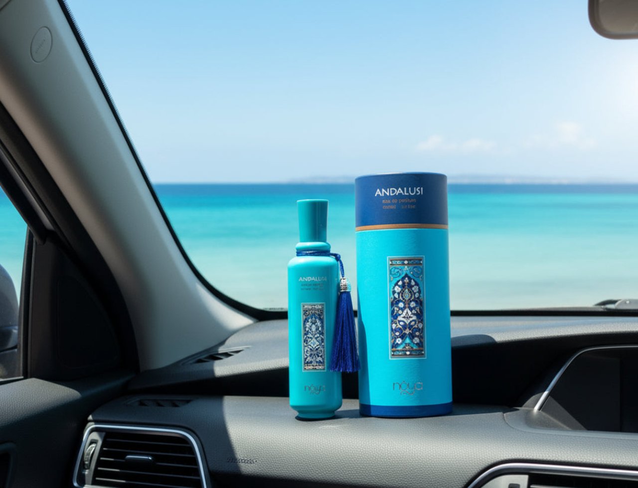 Zimaya Andalusi Blue by Zimaya 100ml EDP Men — Botol teal dan kotak silinder bercorak mozek biru putih, diletakkan di papan pemuka kereta dengan latar belakang lautan biru cerah dan langit.