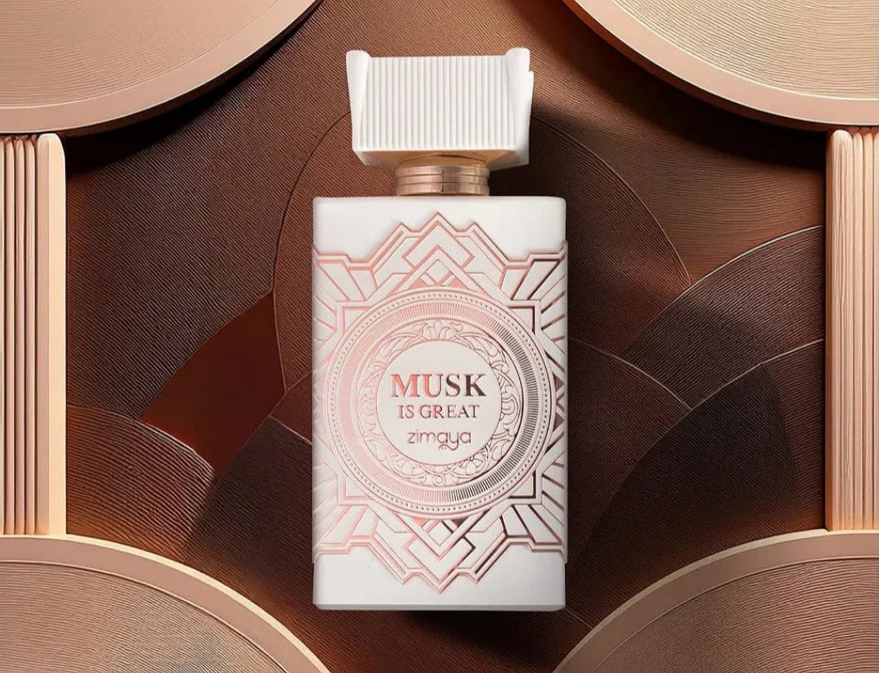 Zimaya Musk Is Great by Zimaya 100ml EDP Unisex — Botol minyak wangi putih dengan corak geometri emas ros dan penutupnya, berlatar belakang coklat bertekstur dan emas ros dengan elemen bulat.