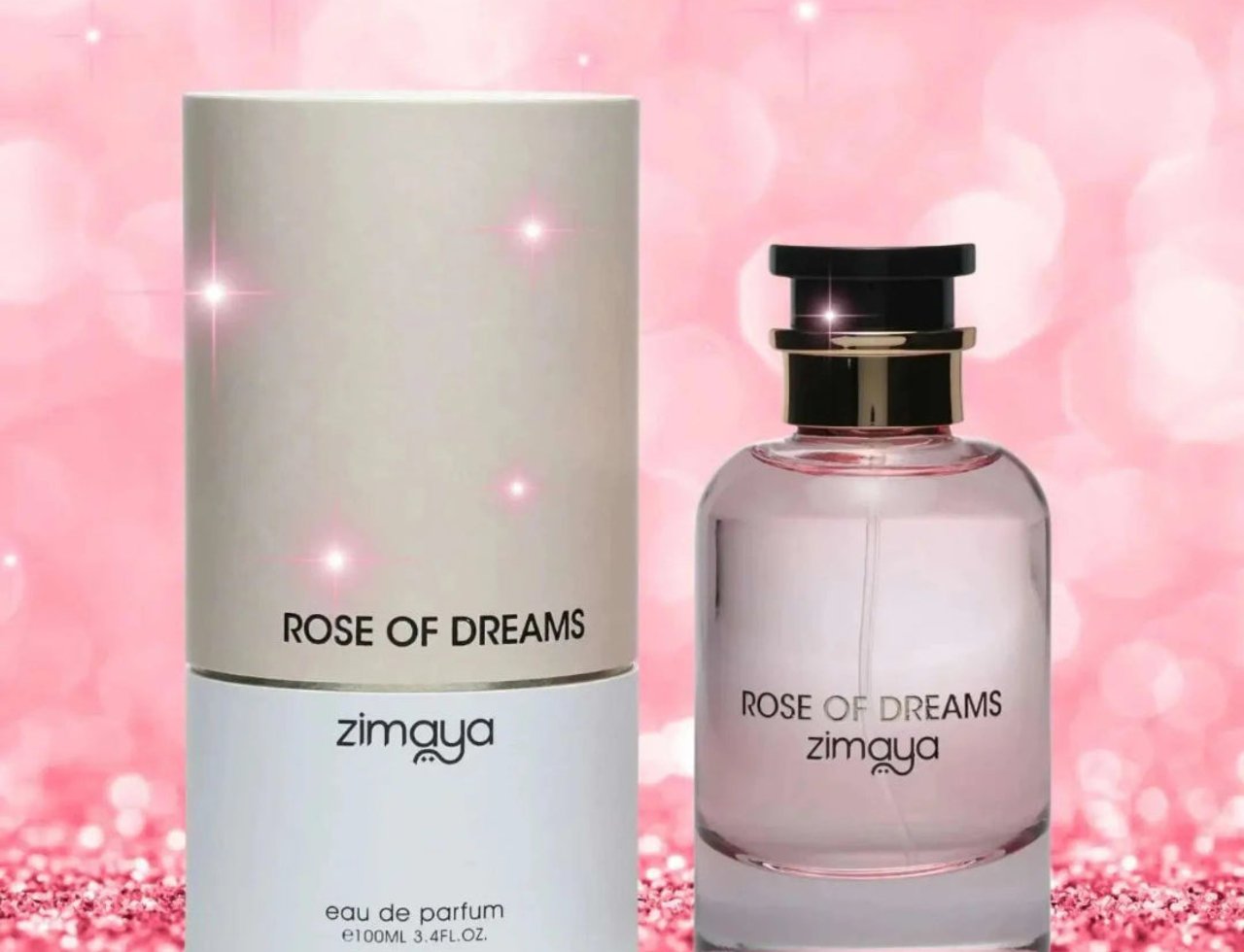Zimaya Rose of Dreams — A clear glass perfume bottle with pink liquid and a black and gold cap, next to its cylindrical beige and white box, set against a sparkling pink bokeh background.