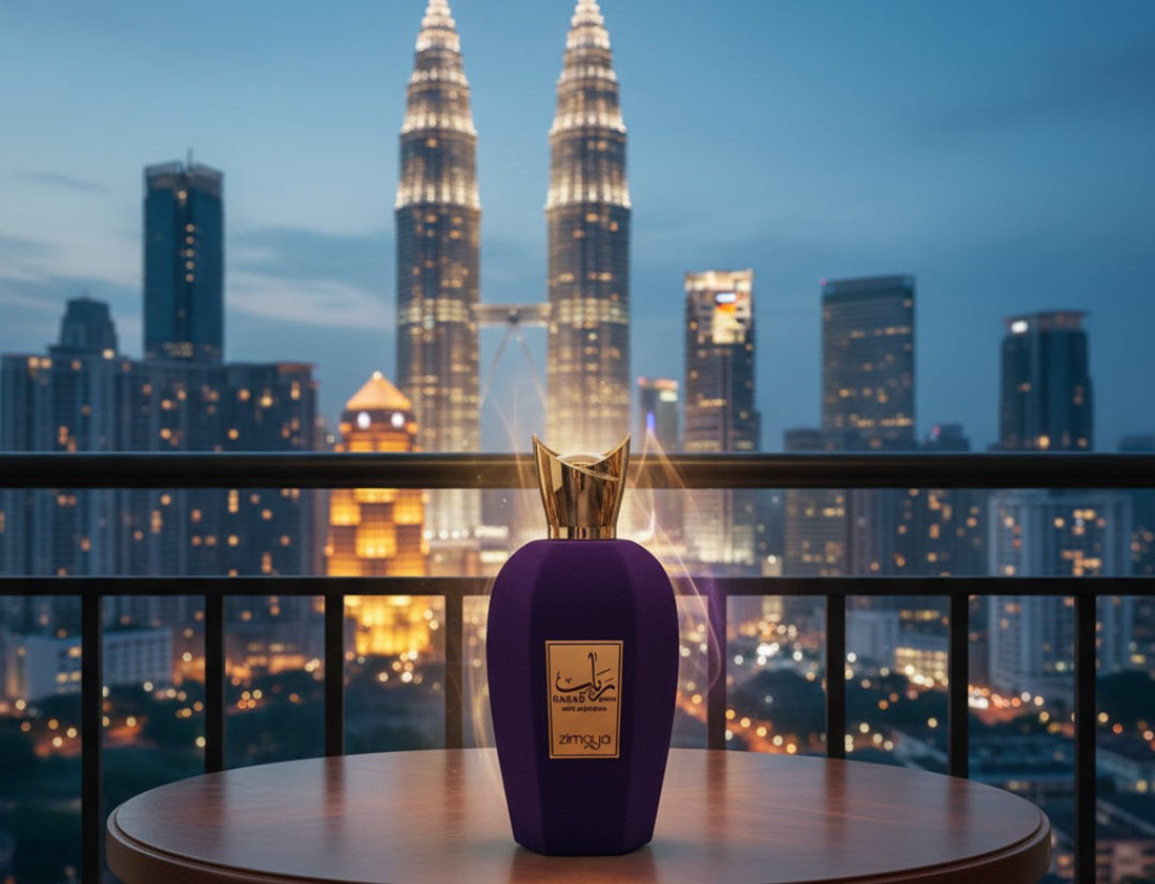 Rabab Gems by Zimaya 100ml EDP Unisex — Botol minyak wangi baldu ungu dengan penutup emas di atas meja kayu, dengan latar belakang Menara Berkembar Petronas dan langit Kuala Lumpur senja.