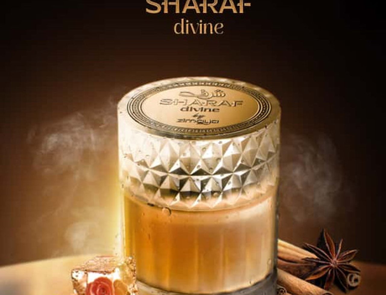 Zimaya Sharaf Divine By Zimaya 100 ml Extrait Unisex — A faceted glass perfume bottle with golden liquid, surrounded by ice cubes with rose imprints and cinnamon sticks with star anise.