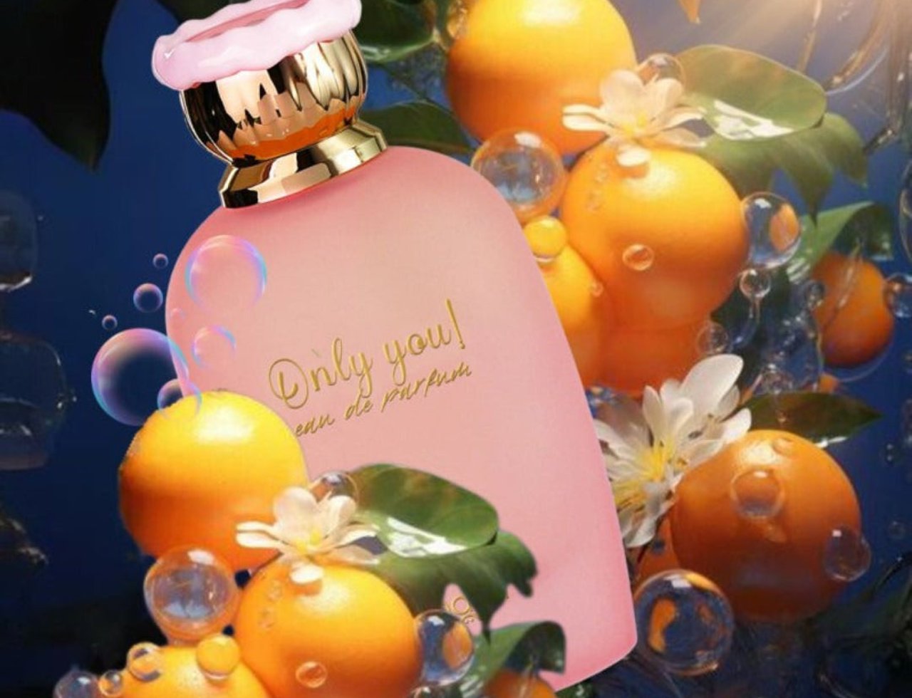Zimaya Only You by Zimaya Perfume Elixir 100ML EDP — Botol minyak wangi merah jambu dengan penutup emas dan merah jambu, dikelilingi buah oren, daun, dan gelembung air.
