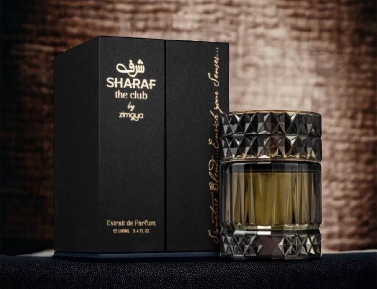 Zimaya Sharaf The Club by Zimaya 100ml Extrait Men — Black box with gold text and a faceted glass perfume bottle with gold accents, set against a textured brown background.