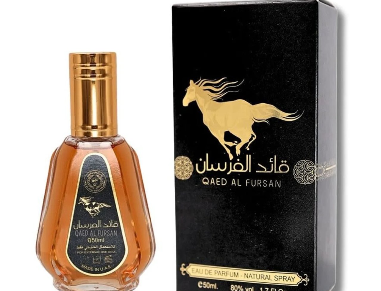 Ard Al Zaafaran Qaed Al Fursan — A golden horse silhouette on a black box next to a glass perfume bottle with a golden cap and amber liquid. | Ard Al Zaafaran Qaed Al Fursan — Siluet kuda keemasan pada kotak hitam di sebelah botol minyak wangi kaca dengan penutup keemasan dan cecair ambar.