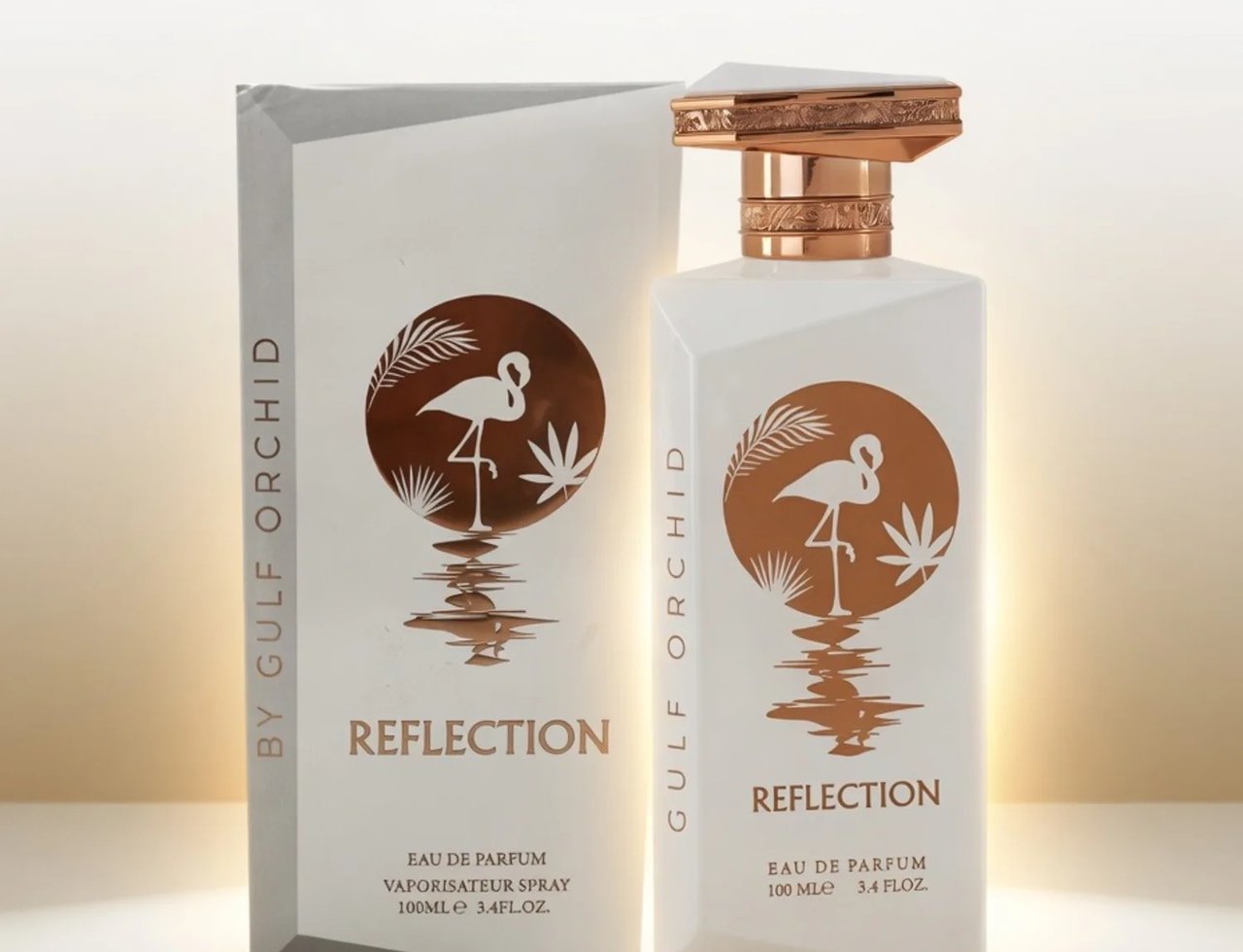 Gulf Orchid Reflection For Her 100ml by Gulf Orchid — White perfume bottle and box with a copper flamingo and palm leaf design, set against a soft golden gradient background. | Gulf Orchid Reflection For Her 100ml by Gulf Orchid — Botol dan kotak minyak wangi putih dengan rekaan flamingo tembaga dan daun palma