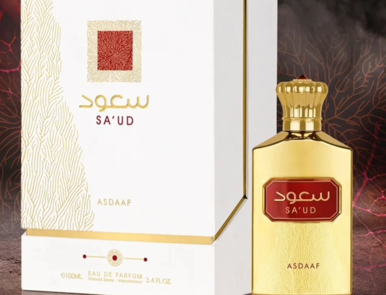 Asdaaf Sa'ud by Asdaaf 100ml EDP Unisex — Botol minyak wangi emas dengan label merah dan tulisan Arab, bersebelahan kotak putih bermotif emas.
