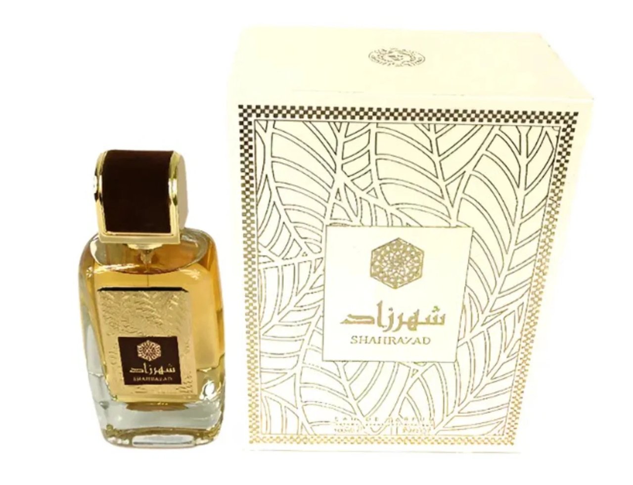 Ard Al Zaafaran Shahrazad Eau De Parfum 100ml — Botol kaca jernih berisi cecair keemasan, dengan penutup coklat gelap dan label emas. Kotak putih dengan corak daun emas turut dipaparkan di sebelah.