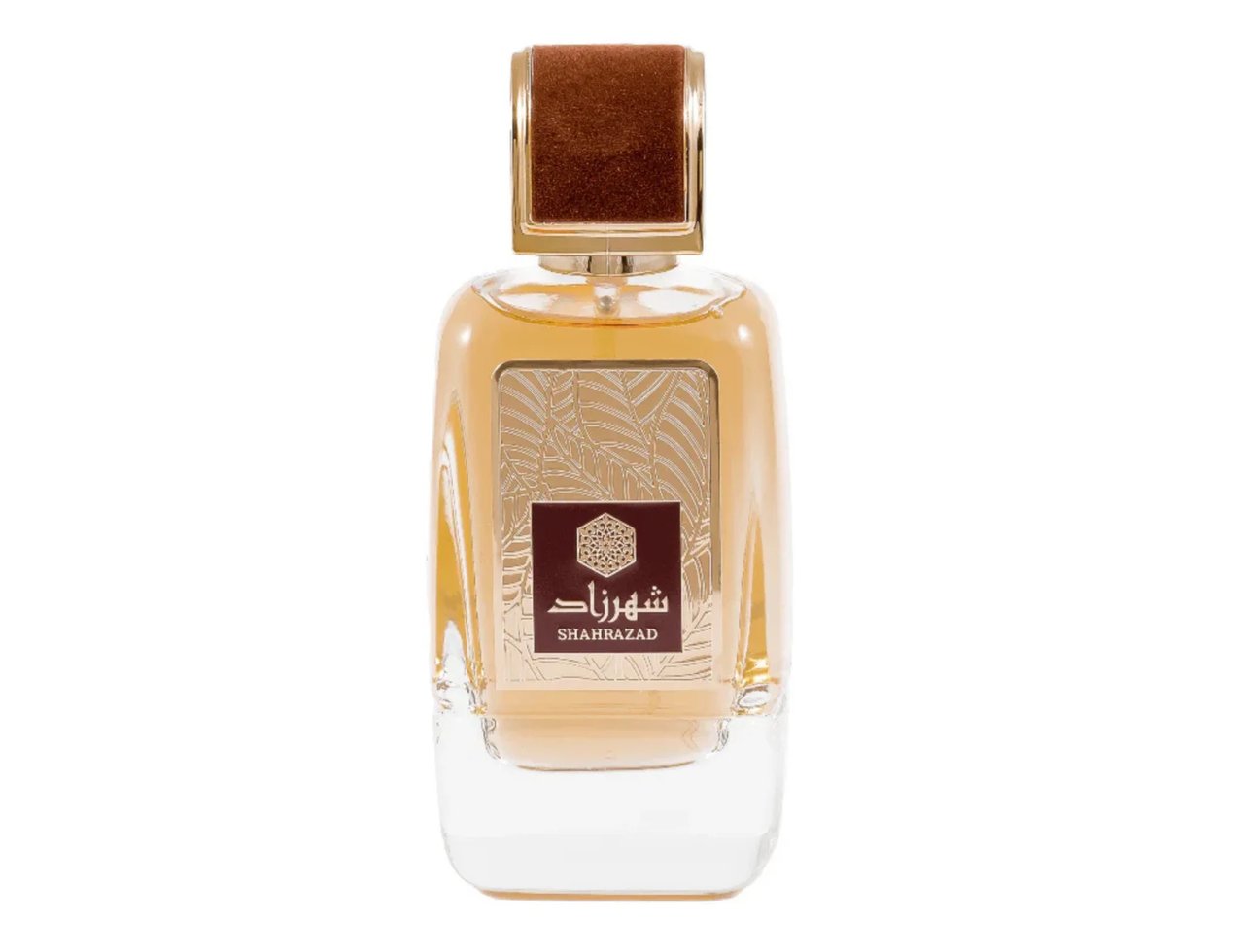 Ard Al Zaafaran Shahrazad Eau De Parfum 100ml — A clear glass perfume bottle with amber liquid, a brown textured cap, and a decorative label featuring Arabic script and a geometric pattern. | Ard Al Zaafaran Shahrazad Eau De Parfum 100ml — Botol kaca jernih dengan cecair berwarna ambar, penutup bertekstur coklat, dan