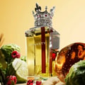 Lattafa Dynasty by Lattafa 100ml EDP Unisex — A crystal perfume bottle with a crown-shaped cap, featuring the "DYNASTY" logo and a red stripe, surrounded by bergamot fruits, raspberries, and amber-colored glass elements.