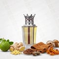 Lattafa Dynasty by Lattafa 100ml EDP Unisex — Perfume bottle with a crown cap, surrounded by bergamot, ginger, tea leaves, amber stones, and a brown cloth.