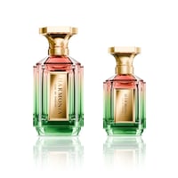 Velixir Harmonia Velixir Parfums 100ml for Unisex — Two glass perfume bottles with a gradient of pink to green liquid, gold caps, and gold labels, displayed side-by-side on a white reflective surface. | Velixir Harmonia Velixir Parfums 100ml untuk Unisex — Dua botol minyak wangi kaca dengan gradien cecair merah jambu