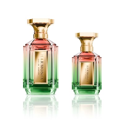 Velixir Harmonia Velixir Parfums 100ml for Unisex — Two glass perfume bottles with a gradient of pink to green liquid, gold caps, and gold labels, displayed side-by-side on a white reflective surface. | Velixir Harmonia Velixir Parfums 100ml untuk Unisex — Dua botol minyak wangi kaca dengan gradien cecair merah jambu