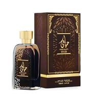 Ard Al Zaafaran Hayaati Oud — A clear glass perfume bottle with dark liquid and a gold cap, next to its brown and gold patterned box, on a white background.