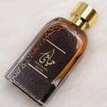 Ard Al Zaafaran Hayaati Oud by Ard Al Zaafaran 100ml EDP Unisex — Amber liquid in a clear glass bottle with a dark patterned label and a gold cap, angled on a white fluffy surface.