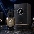 Zimaya Kibria Supremo oleh Zimaya 100ml Man — Botol minyak wangi kaca gelap bertutup hitam bentuk mahkota, berdiri sebelah kotak persembahan hitam bertekstur di atas permukaan marmar.