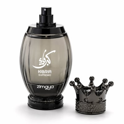 Zimaya Kibria Supremo — A smoky grey oval perfume bottle with white Arabic calligraphy and text 'KIBRIA SUPREMO ZIMAYA' stands next to a dark metallic crown-shaped cap on a white background.