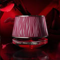 Maison Asrar Kiss My Lips by Maison Asrar 90ml EDP Unisex — Botol minyak wangi kaca merah bertudung merah jambu bertekstur, berlatar belakang merah kabur dengan bayangan kelopak dan bibir.