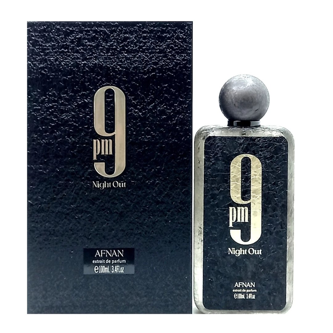Afnan 9 PM Night Out Extrait de Parfum — A dark textured box stands next to a clear glass perfume bottle with a textured dark label and a grey spherical cap. | Afnan 9 PM Night Out Extrait de Parfum — Kotak bertekstur gelap berdiri di sebelah botol minyak wangi kaca jernih dengan label gelap bertekstur dan penutup