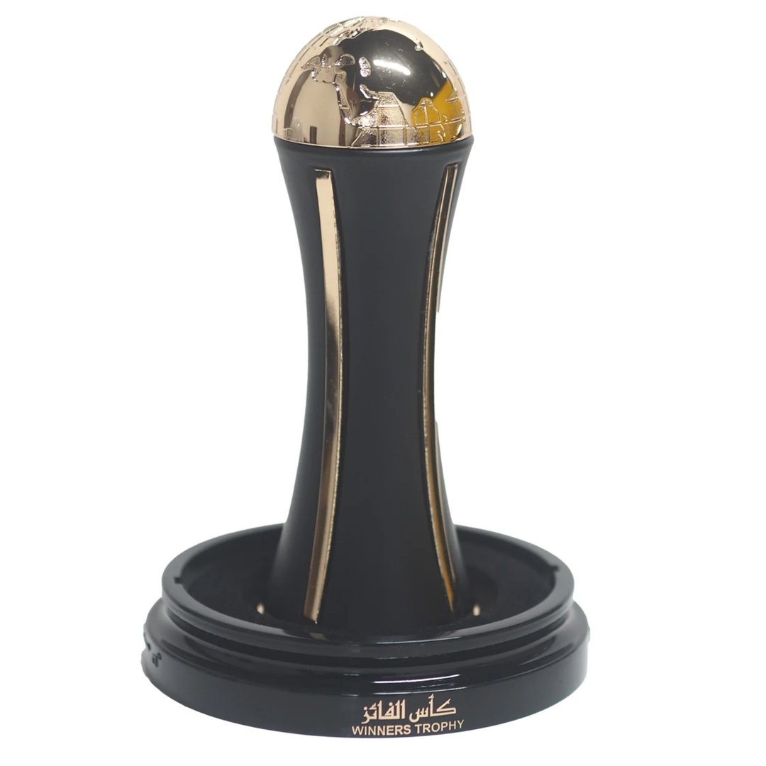 Lattafa Pride Al Khas Winners Trophy Gold 100ml — A black and gold trophy with a globe on top, set on a black base with Arabic and English text. | Lattafa Pride Al Khas Winners Trophy Gold 100ml — Piala hitam dan emas dengan globe di atasnya, diletakkan di atas tapak hitam dengan teks Arab dan Inggeris.