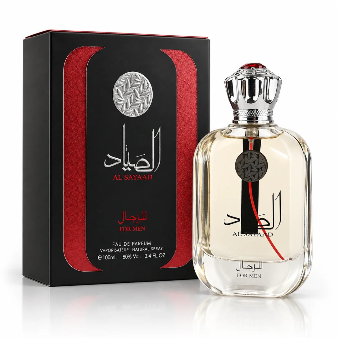 Ard Al Zaafaran Al Sayaad For Men EDP — Black textured box with red accents and silver emblem next to a clear glass perfume bottle with a silver crown-like cap and red accents.