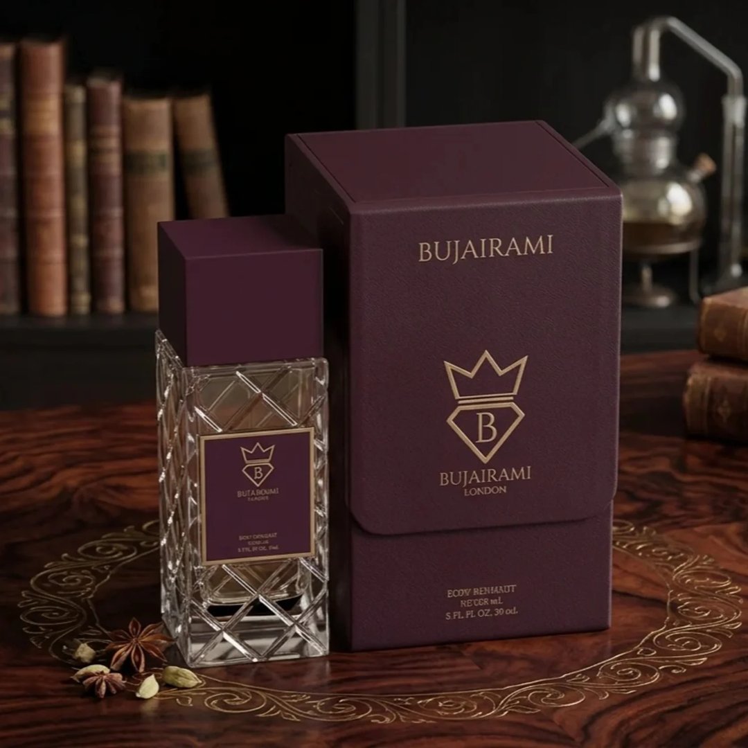 Bujairami Amber Eclipse by Bujairami 100ml Extrait — A clear glass perfume bottle with a textured diamond pattern and a deep purple cap, standing next to its matching deep purple presentation box. The box features a gold crown logo and brand name. The scene is set on a polished wooden surface with scattered star anise