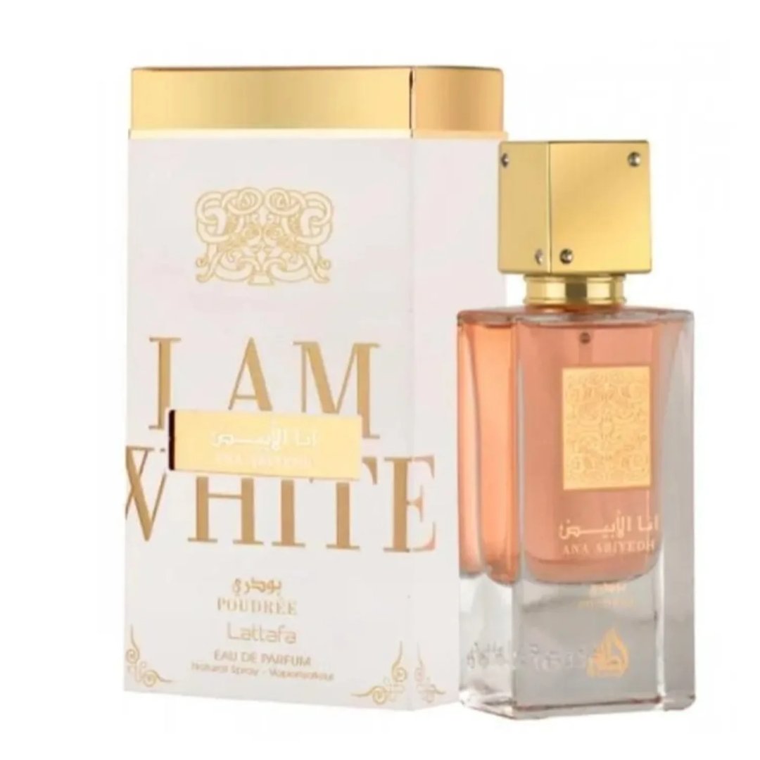 Lattafa Ana Abiyedh Poudree — A white perfume box with gold accents and Arabic script stands next to a clear glass perfume bottle with a rose-gold liquid and a gold cap. | Kotak minyak wangi putih Lattafa Ana Abiyedh Poudree dengan aksen emas dan tulisan Arab berdiri di sebelah botol minyak wangi kaca jernih dengan