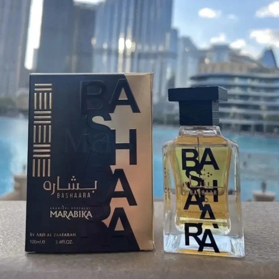 Ard Al Zaafaran Bashaara Eau De Parfum 100ml by Ard Al Zaafaran - Kotak wangian hitam keemasan dan botol kaca jernih berisi cecair keemasan, latar belakang bangunan moden