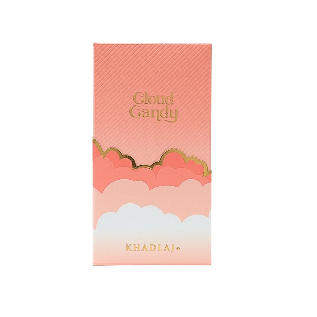 Khadlaj Cloud Candy Eau De Parfum 100ml — A pink box with diagonal lines at the top, transitioning to a cloud design with gold trim, and the brand name 'KHADLAJ' at the bottom. | Khadlaj Cloud Candy Eau De Parfum 100ml — Kotak merah jambu dengan garisan pepenjuru di bahagian atas, bertukar kepada reka bentuk awan