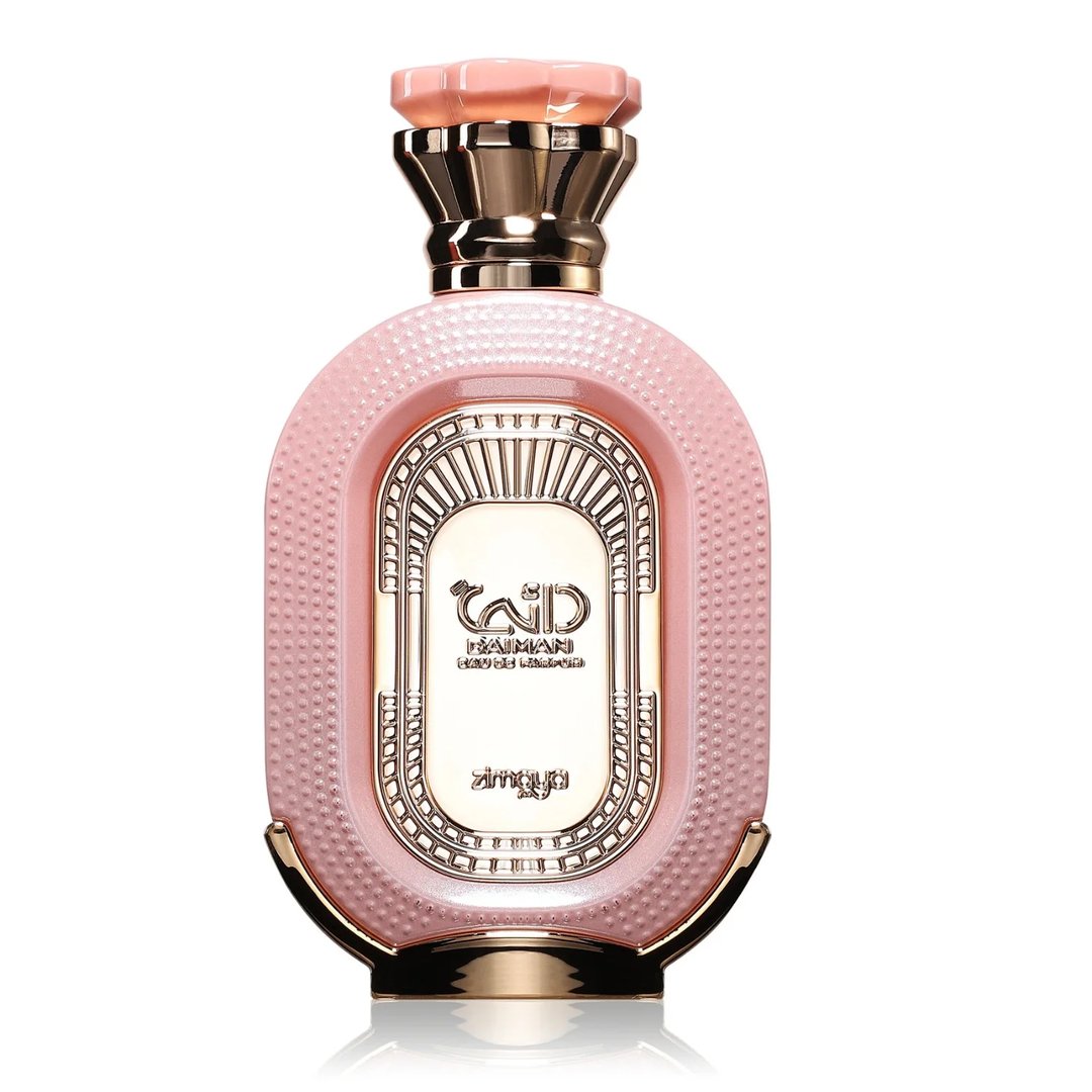 Zimaya Daiman Eden Eau De Parfum 100ml by Zimaya — A pink oval perfume bottle with a textured surface, gold accents, and a faceted pink and gold cap, set against a white background with a subtle reflection. | Zimaya Daiman Eden Eau De Parfum 100ml by Zimaya — Botol minyak wangi bujur merah jambu dengan permukaan