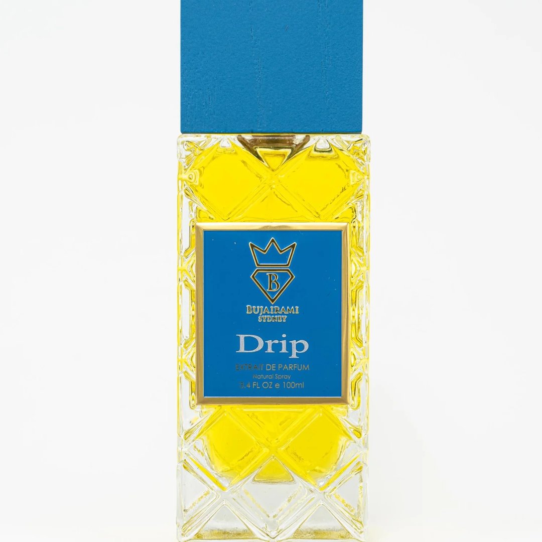 Bujairami Drip by Bujairami 100ml Extrait — Yellow liquid in a clear, diamond-patterned glass bottle with a blue cap and gold accents on the label.
