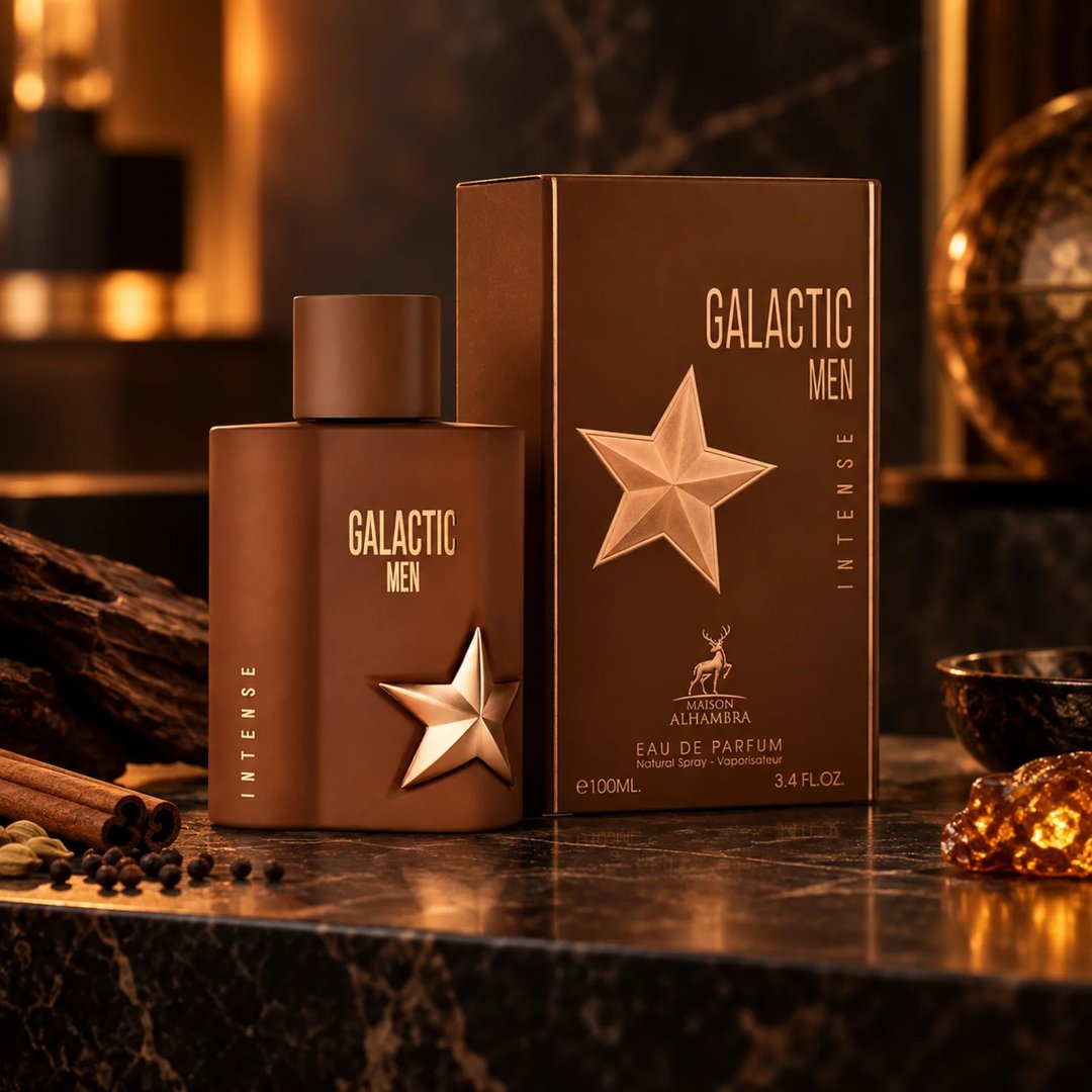 Maison Alhambra Galactic Men Intense — Brown perfume bottle and box with gold star accents, set on a marble surface with spices and wood.