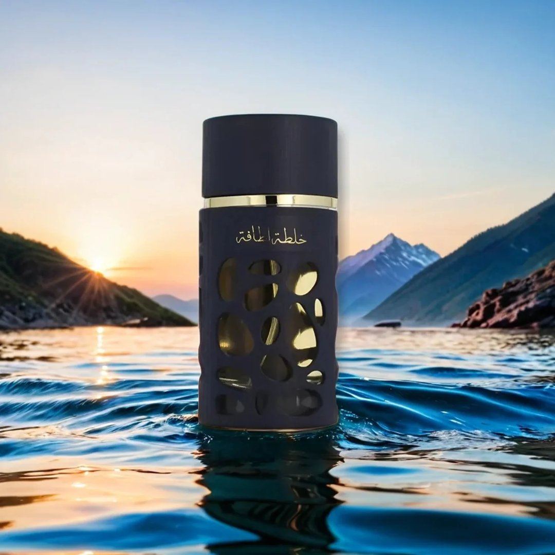 Lattafa Khalta Blend Of Lattafa Eau De Parfum 100ml — Botol minyak wangi gelap dengan rekaan berlubang dan kemasan emas, terapung di atas air dengan latar belakang gunung dan matahari terbenam.