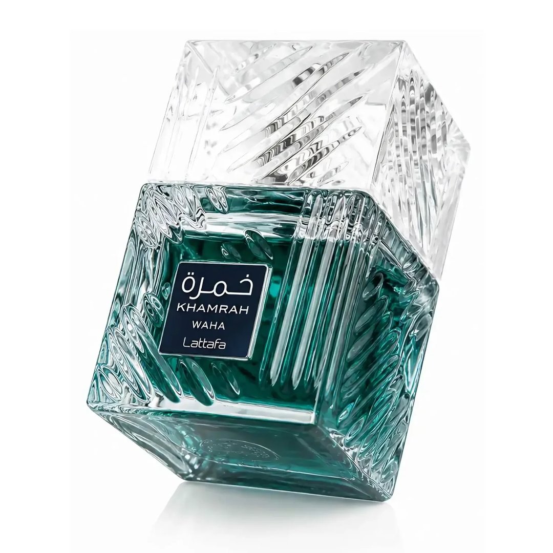 Lattafa Khamrah Waha Lattafa Perfumes 100ml EDP — A square, clear glass perfume bottle with a textured, faceted design and green liquid, tilted on a white background. | Lattafa Khamrah Waha Lattafa Perfumes 100ml EDP — Botol minyak wangi kaca jernih berbentuk segi empat dengan reka bentuk bertekstur dan faset serta