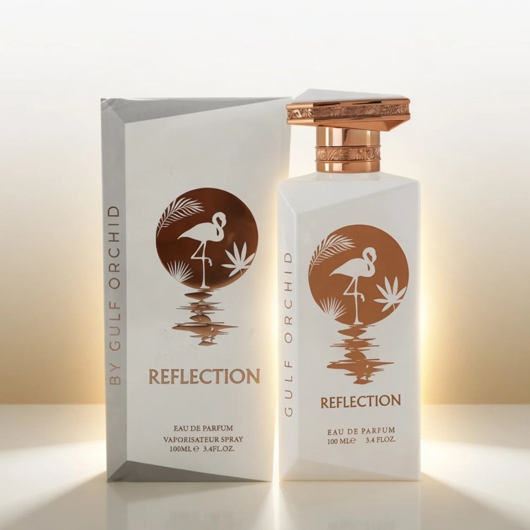 Gulf Orchid Reflection For Her 100ml by Gulf Orchid — White perfume bottle and box with a copper flamingo and palm leaf design, set against a soft golden gradient background. | Gulf Orchid Reflection For Her 100ml by Gulf Orchid — Botol dan kotak minyak wangi putih dengan rekaan flamingo tembaga dan daun palma