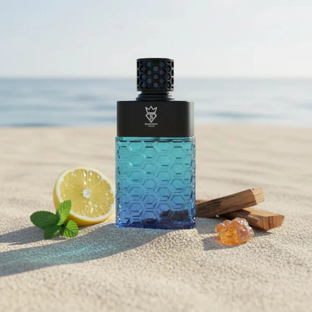 Bujairami Sovereign by Bujairami 100ml EDP — A blue gradient hexagonal patterned bottle on a sandy beach with a lemon slice, mint leaves, and amber resin.