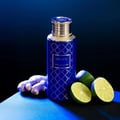 Legacy by Maison Asrar 100ml EDP Unisex — Botol biru corak geometri emas, penutup emas, dan label hiasan, diletakkan di atas permukaan gelap bersama akar halia dan hirisan limau.