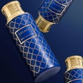 Maison Asrar Legacy by Maison Asrar 100ml EDP Unisex — Tiga botol minyak wangi biru corak emas rumit dan penutup emas, disusun berlatarkan latar belakang biru gelap gradien.