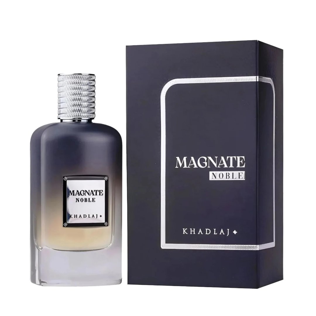 Khadlaj Magnate Noble — A dark grey gradient perfume bottle with a silver textured cap sits next to its matching dark navy box with silver trim. | Khadlaj Magnate Noble — Botol minyak wangi kelabu gradien gelap dengan penutup bertekstur perak terletak di sebelah kotak biru laut gelap yang sepadan dengan trim perak.