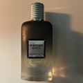 Khadlaj Magnate Noble by Khadlaj 100ml EDP — A clear glass perfume bottle with a dark gradient and a textured silver cap, featuring a metallic label with black text. | Khadlaj Magnate Noble by Khadlaj 100ml EDP — Botol minyak wangi kaca jernih dengan gradien gelap dan penutup perak bertekstur, menampilkan label logam