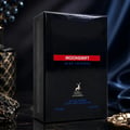 Maison Alhambra Moondrift Blue Intense 100ml — A black perfume box with red and blue text, featuring a deer logo, set against a dark, luxurious background with fabric folds and decorative elements. | Maison Alhambra Moondrift Blue Intense 100ml — Kotak minyak wangi hitam dengan teks merah dan biru, menampilkan logo