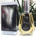 Ard Al Zaafaran Najdia by Ard Al Zaafaran 50ml EDP — Perfume bottle with golden liquid and silver cap next to its black and silver leaf-patterned box.