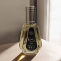 Ard Al Zaafaran Najdia by Ard Al Zaafaran 50ml EDP — Clear glass perfume bottle with a silver cap, featuring a black label with Arabic and English text, placed on a light-colored surface with a shadow.