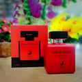 Maison Alhambra Narissa Ruby — Red perfume bottle and its matching red box with a deer silhouette, set against a blurred background of colorful flowers. | Maison Alhambra Narissa Ruby — Botol minyak wangi merah dan kotak merahnya yang sepadan dengan siluet rusa, berlatarkan latar belakang bunga berwarna-warni yang